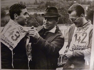 Die Mittelstreckenläufer Karl Eyerkaufer (rechts) und Jürgen May legen Ende der Sechziger Jahre bei einem Sportfest im Rhein-Main-Gebiet mit Hilfe eines Offiziellen die Startnummern an. Eyerkaufer hatte die Flucht des den DDR-Spitzensportler 1967 auf eigene Kosten organisiert. Repro: Nissen